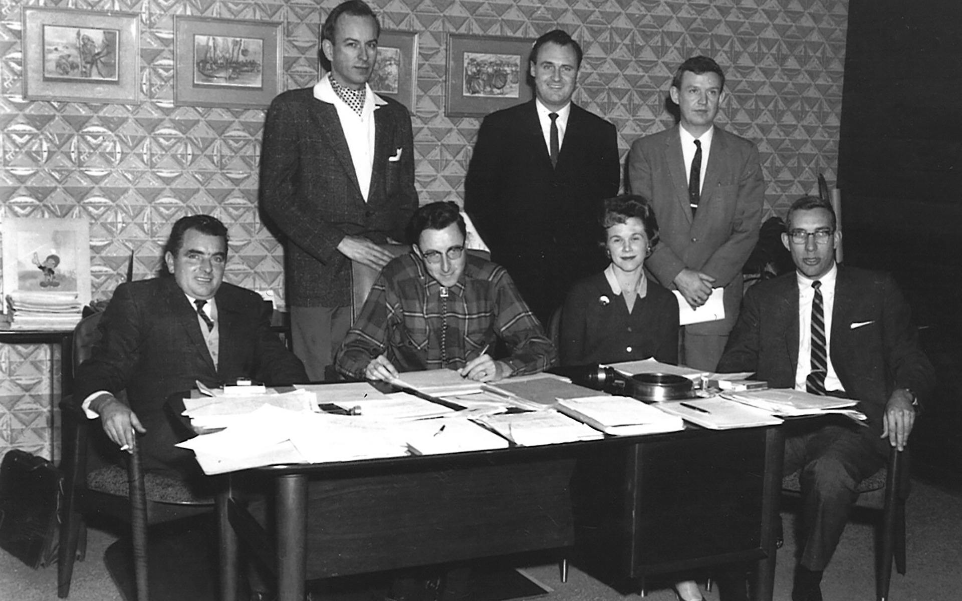 archival image from 1960s of men and women around table