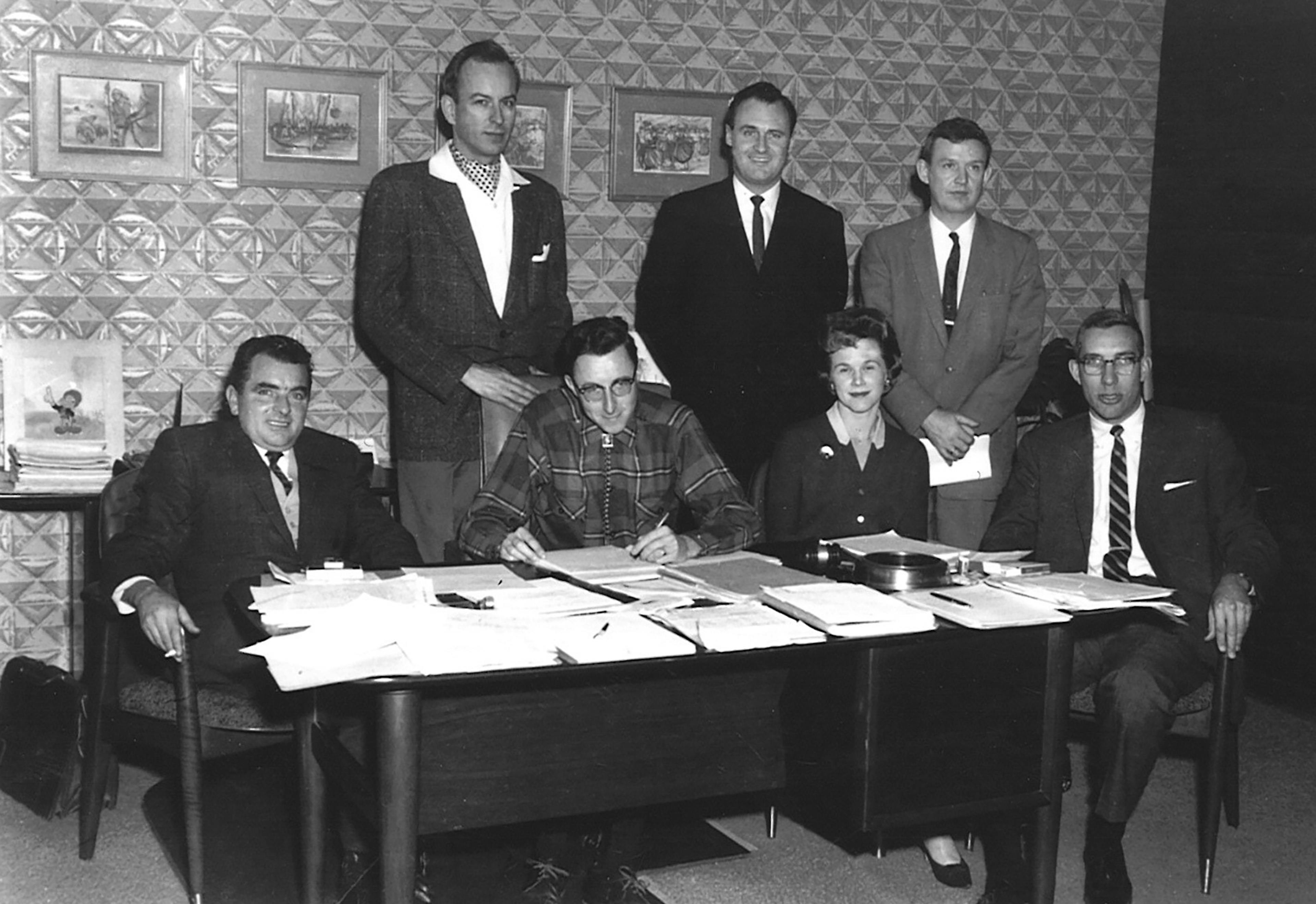 archival image from 1960s of men and women around table