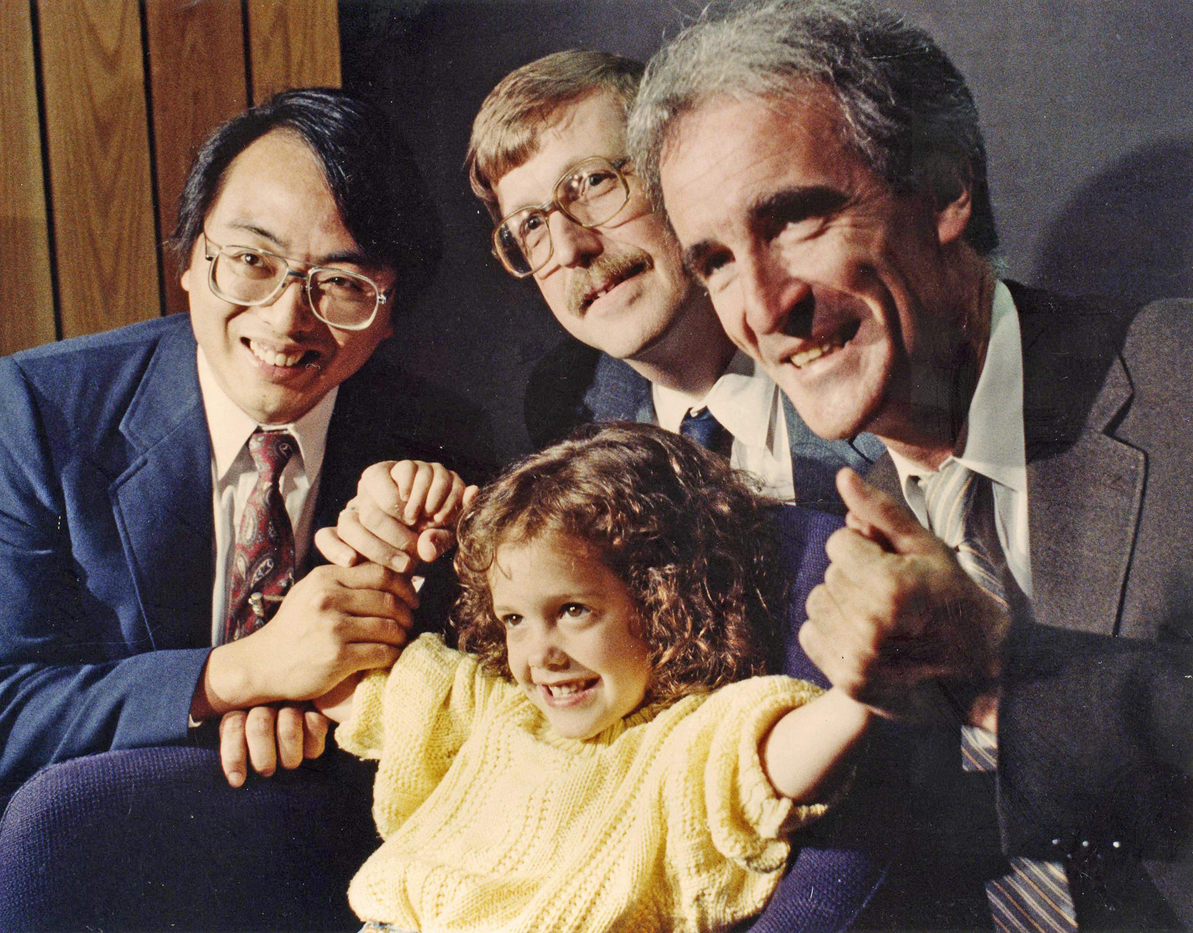 three men celebrate with a young girl