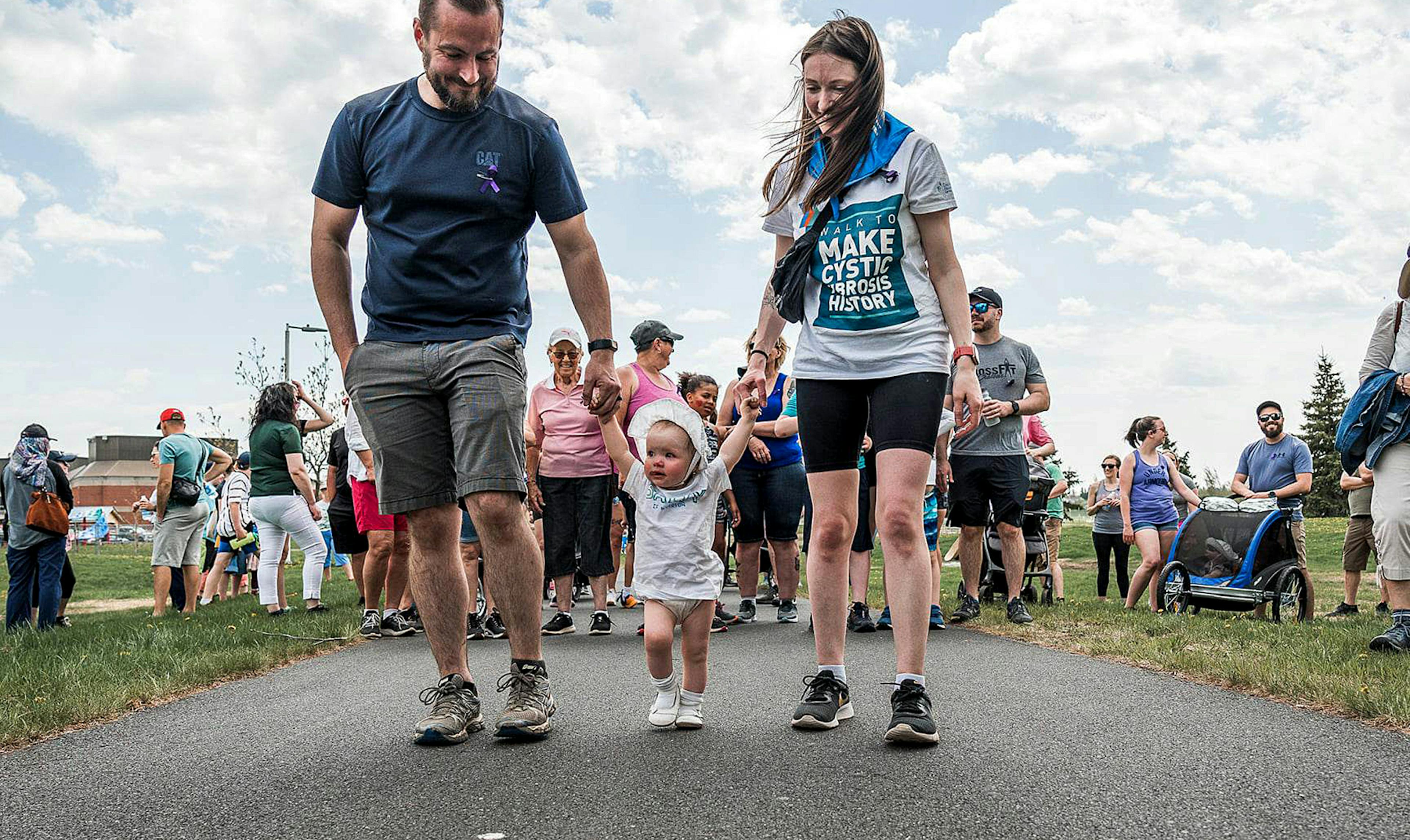 Les parents tiennent la main d'un tout-petit lors de la marche.