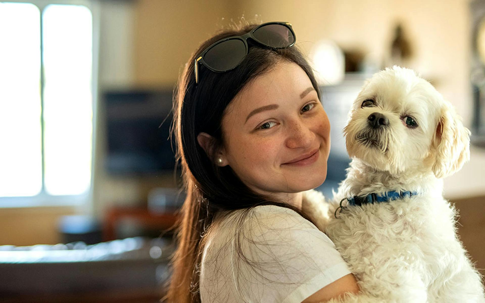 Chanelle holding her small white dog