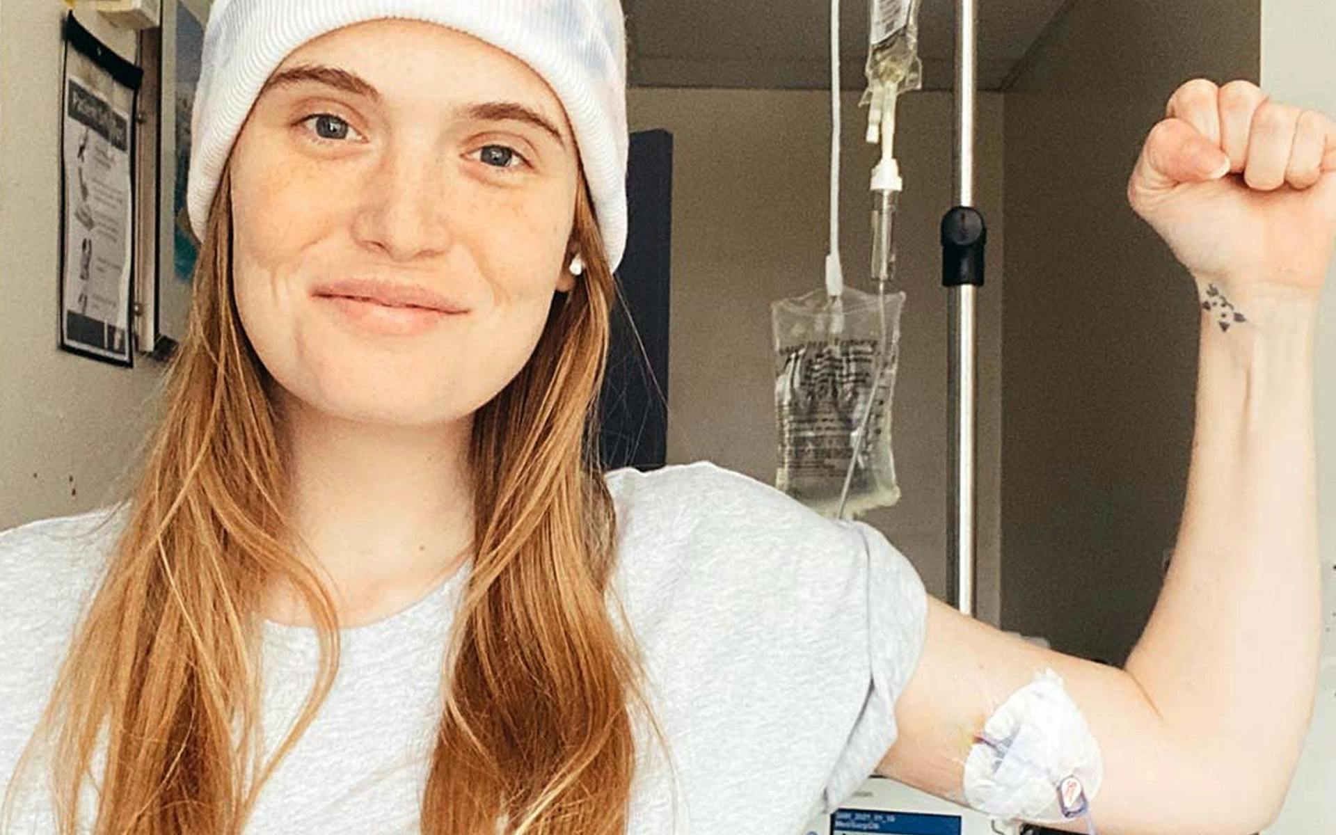 Hilary, holding her fist in the air in hospital.