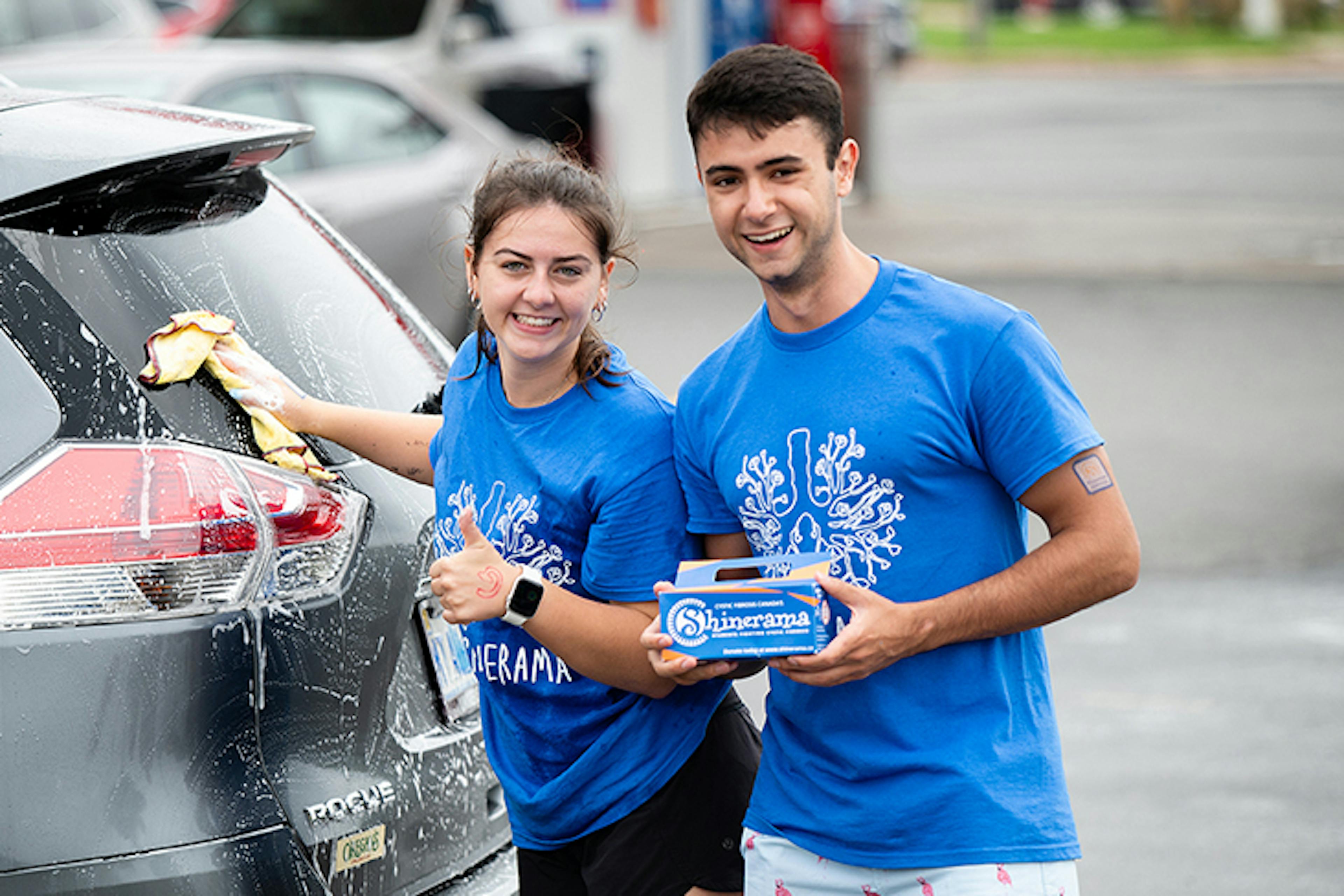 Two young people wash cars for a CF Canada fundraiser