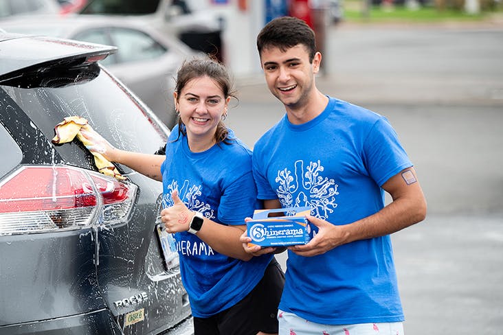 deux jeunes personnes lavant des autos pour collecter des fonds