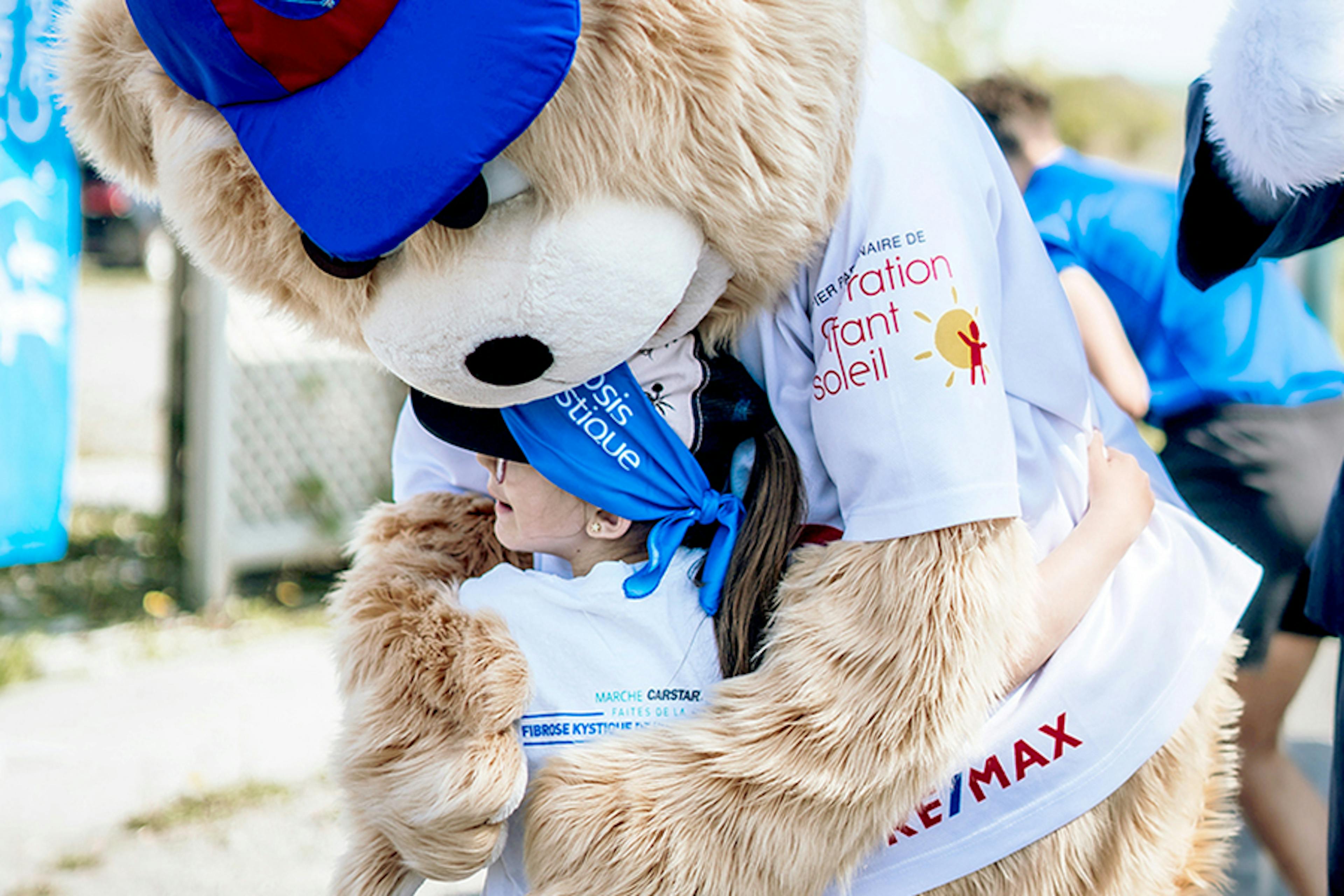 Mascot hugs young child at CF Canada fundraising event