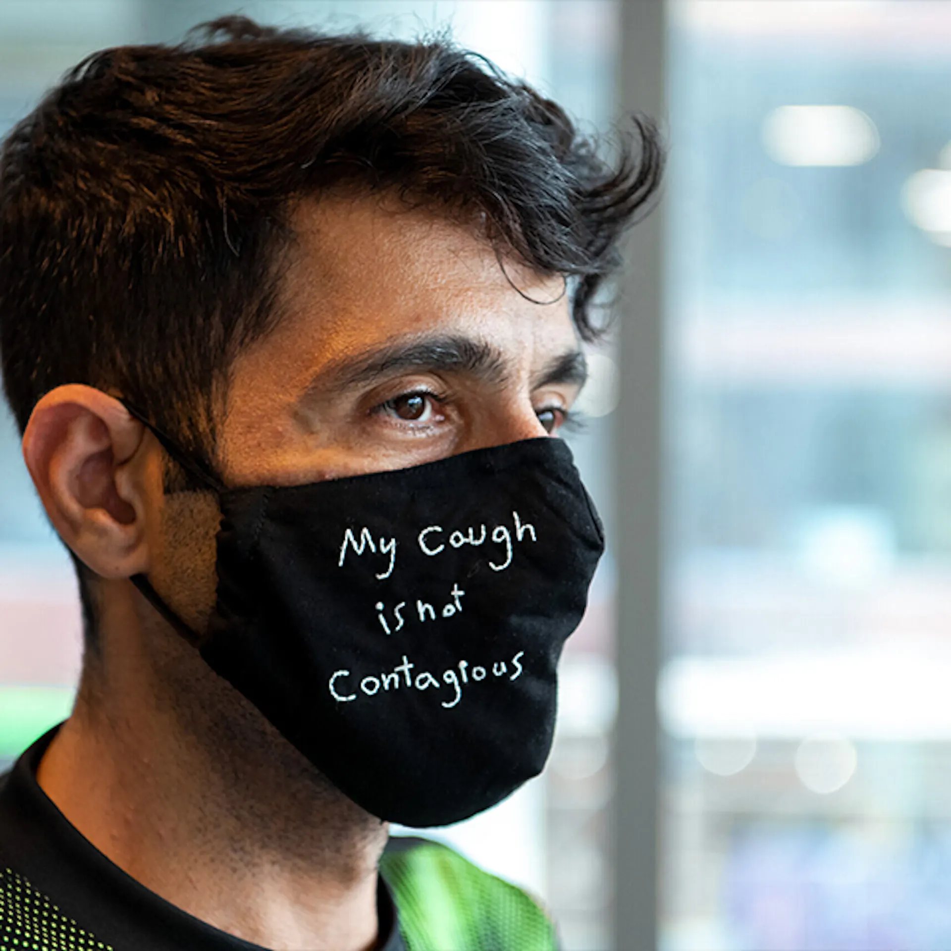 Man poses with mask that reads ‘my cough if not contagious’