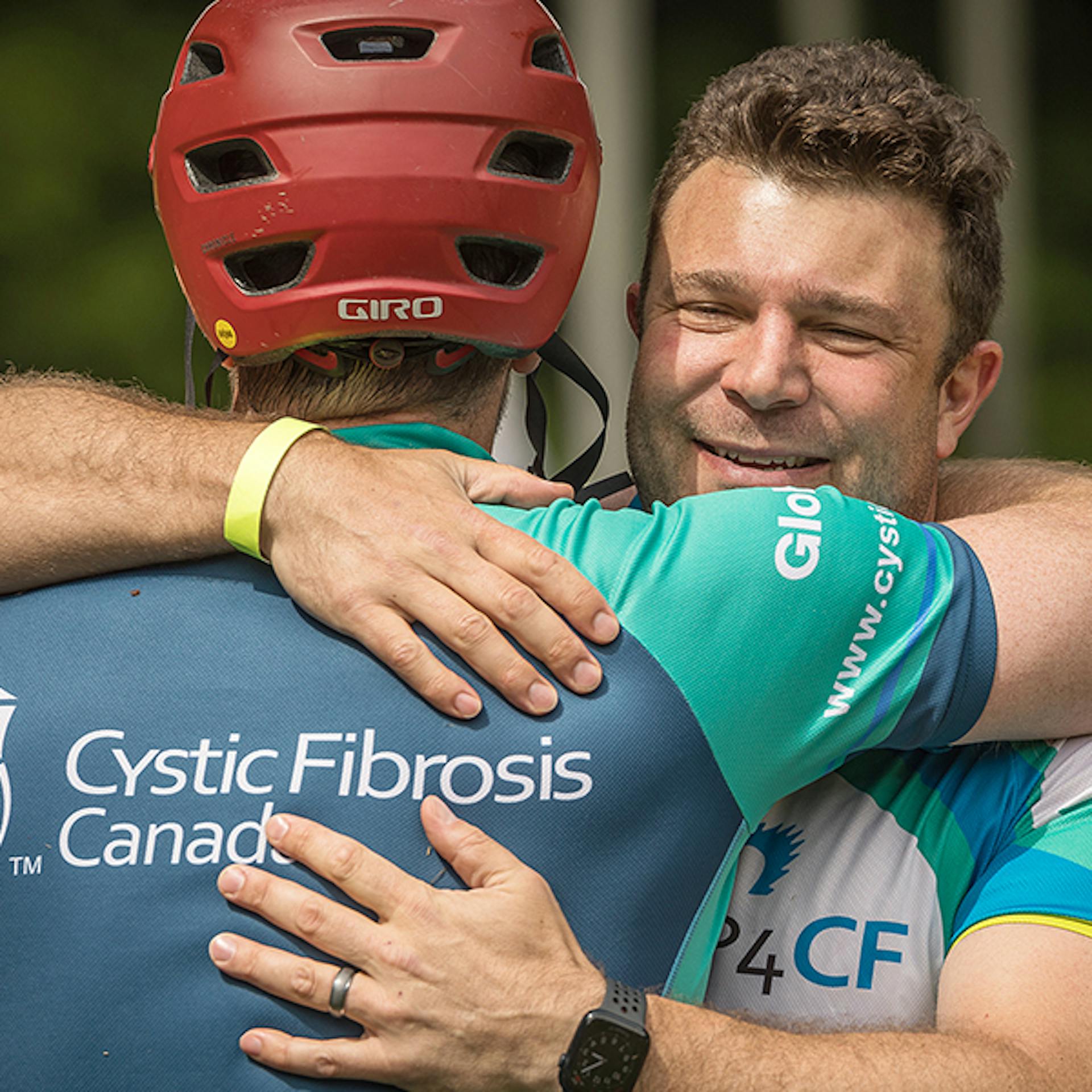 Two men embrace at a cycling fundraiser