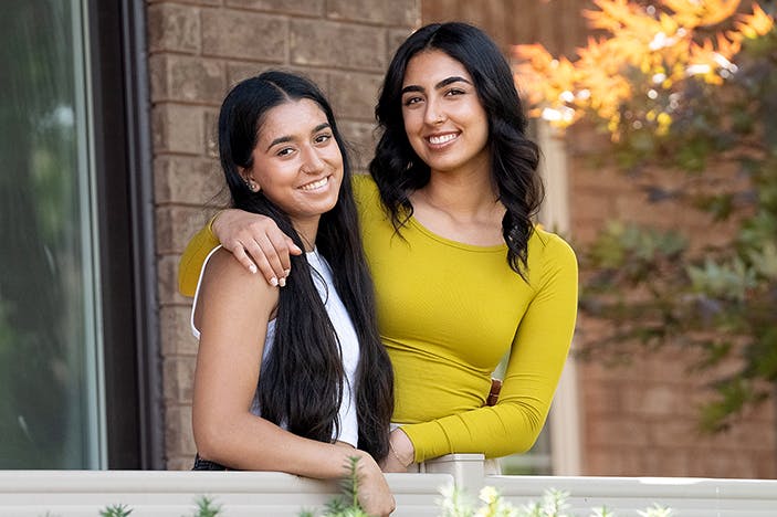 A young woman with CF and her sister embrace on their porch