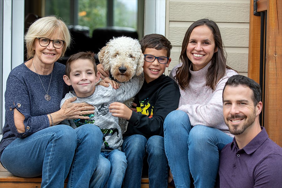 A family in the CF community sit together on their front porch