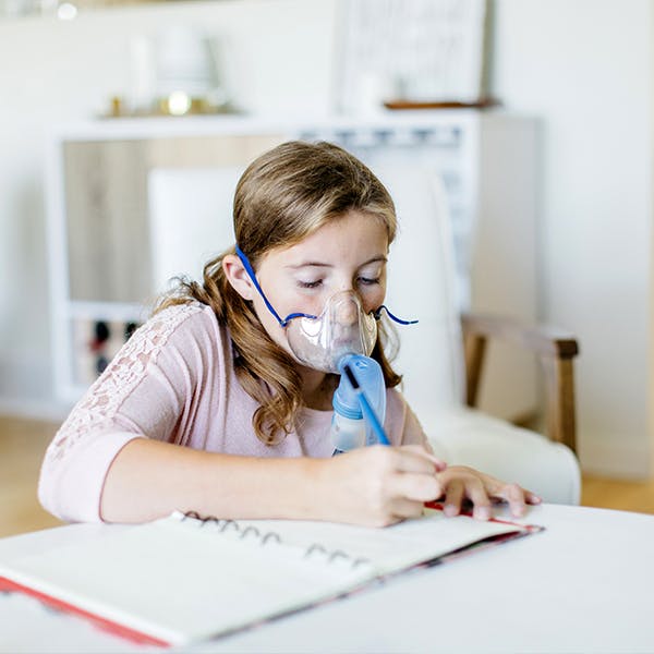 Young girl with CF uses a breathing apparatus