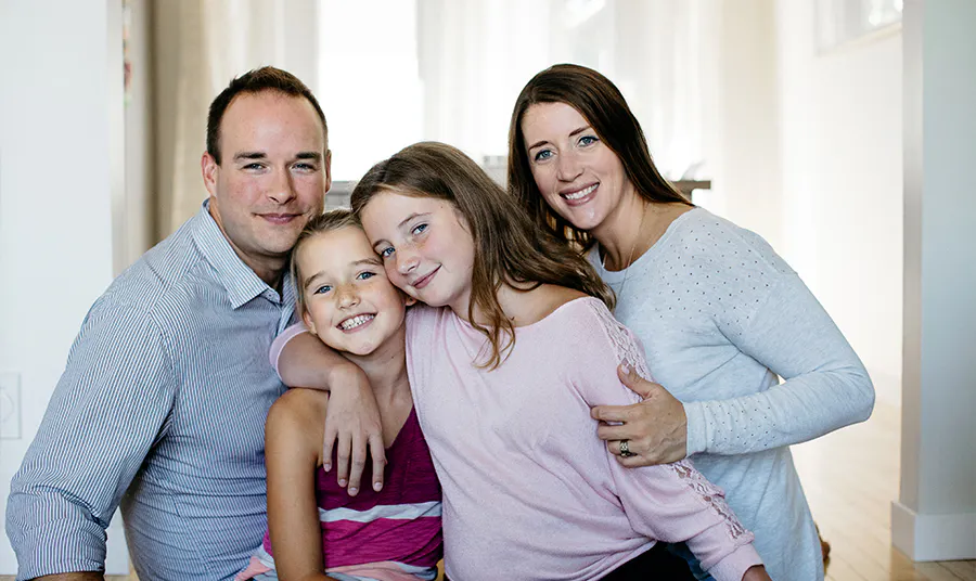 A family of two parents and two children pose together