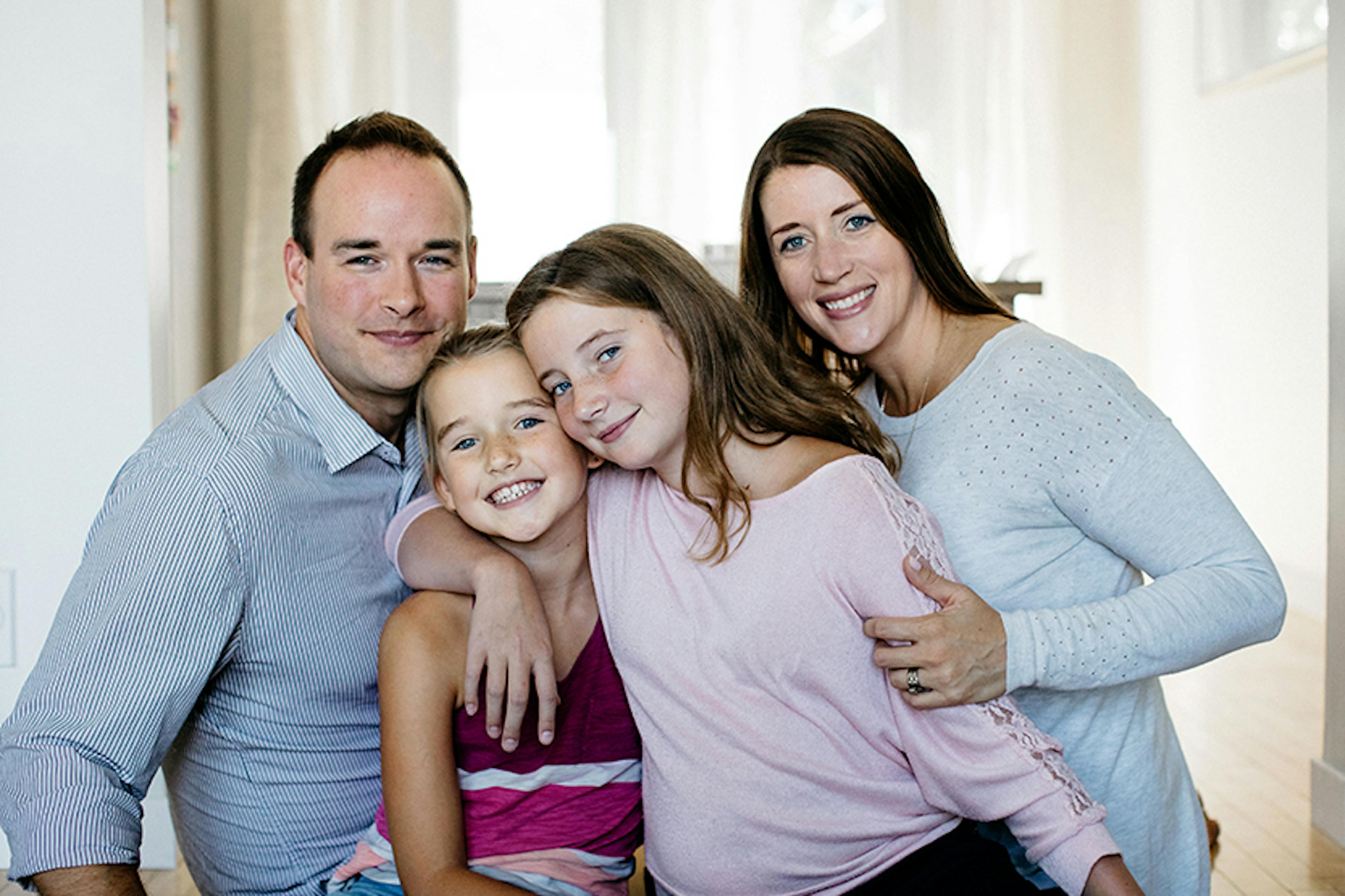 A family of two parents and two children pose together