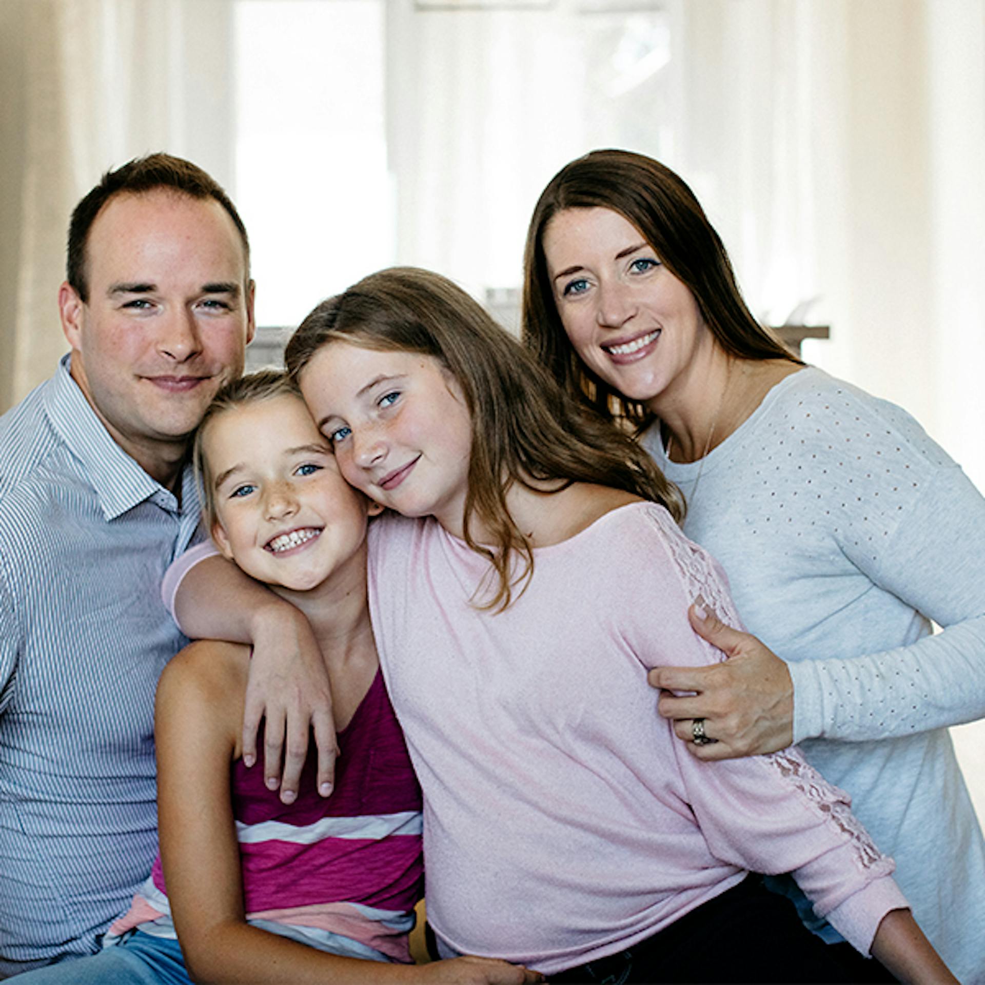 A family of two parents and two children pose together