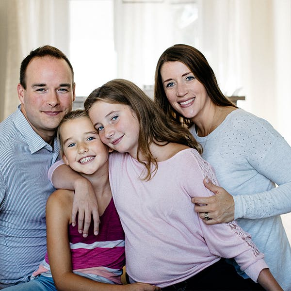 A family of two parents and two children pose together