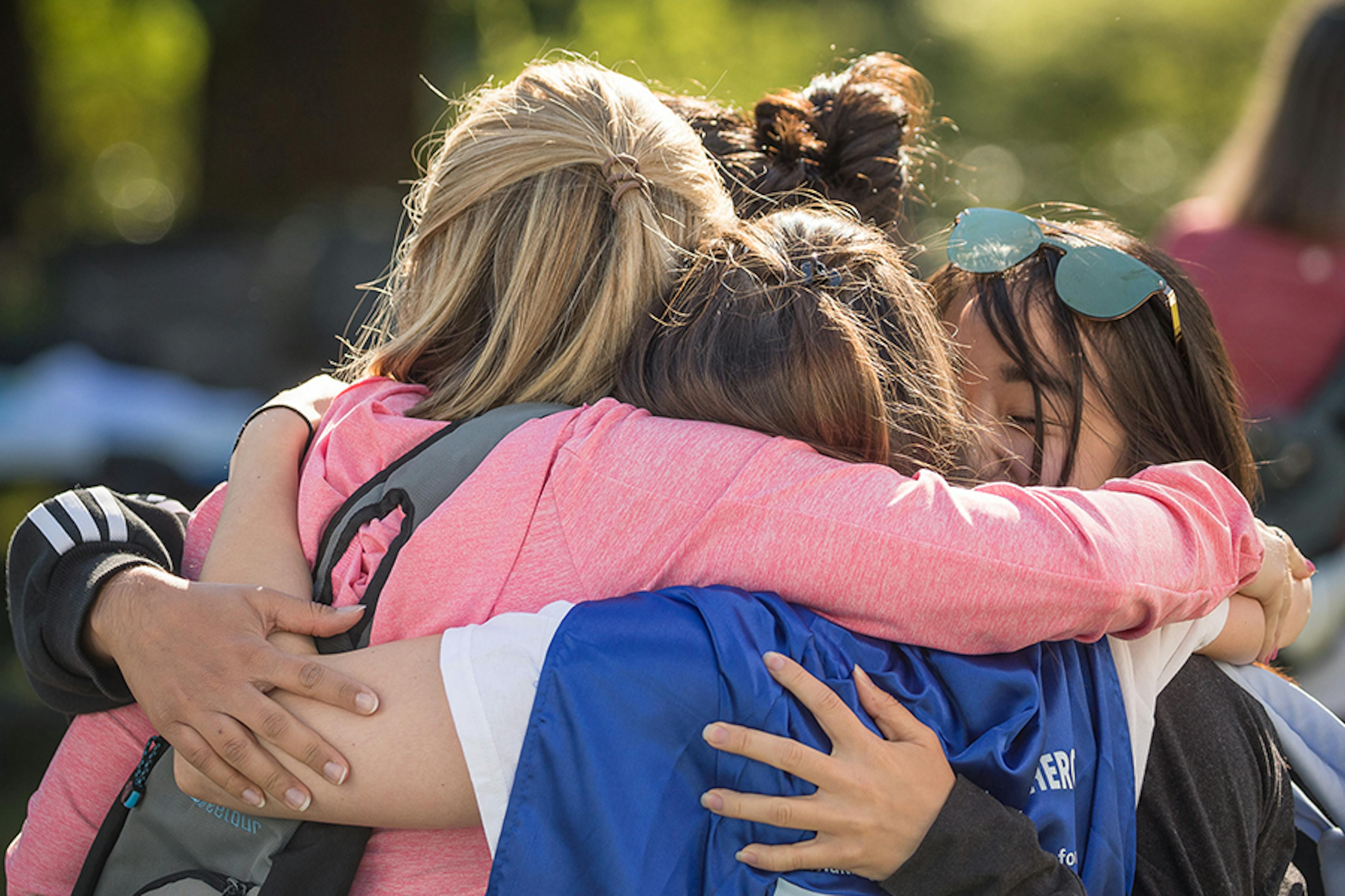 A group of friends hug at a fundraising event