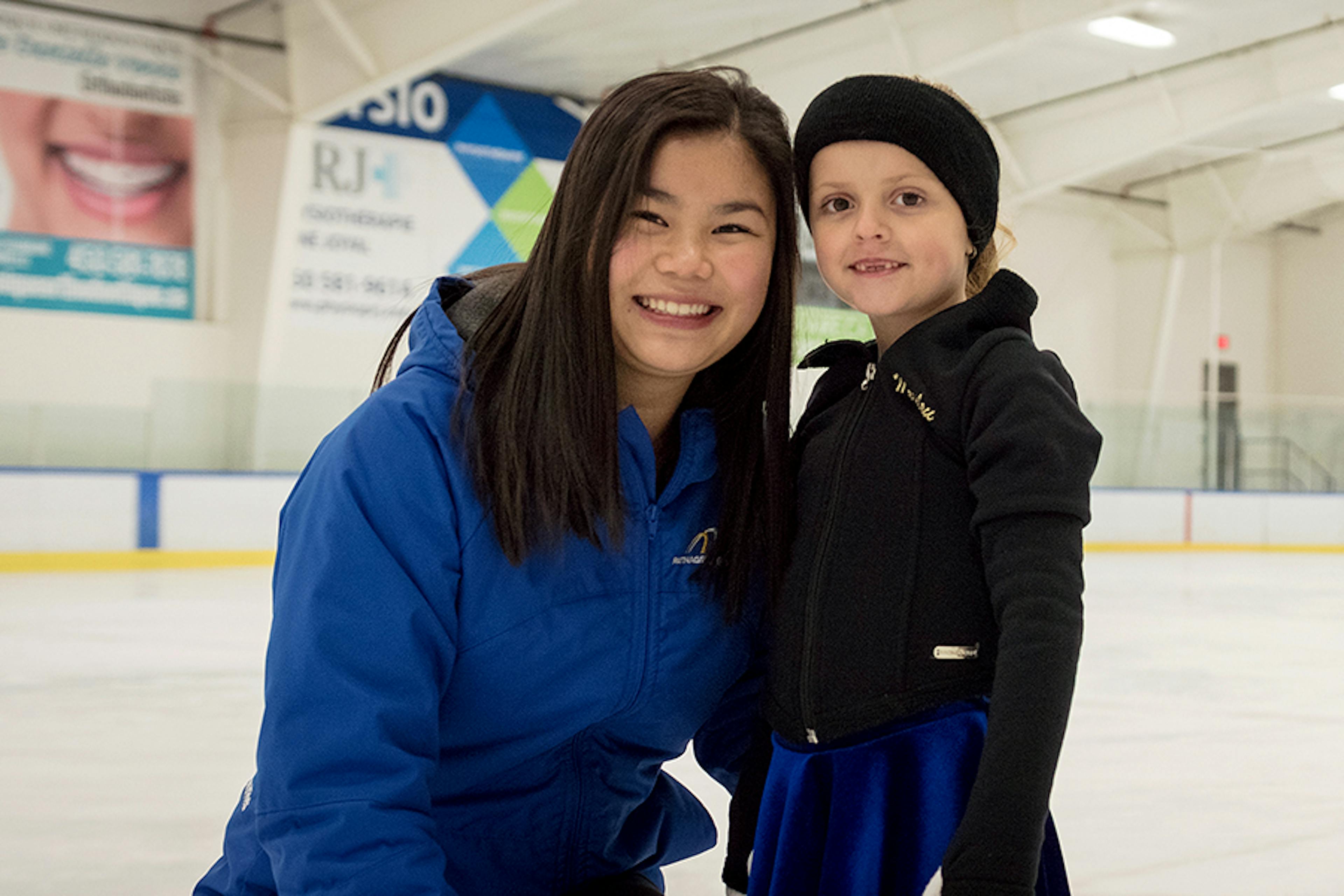 A young female figure skater on the ice with her coach