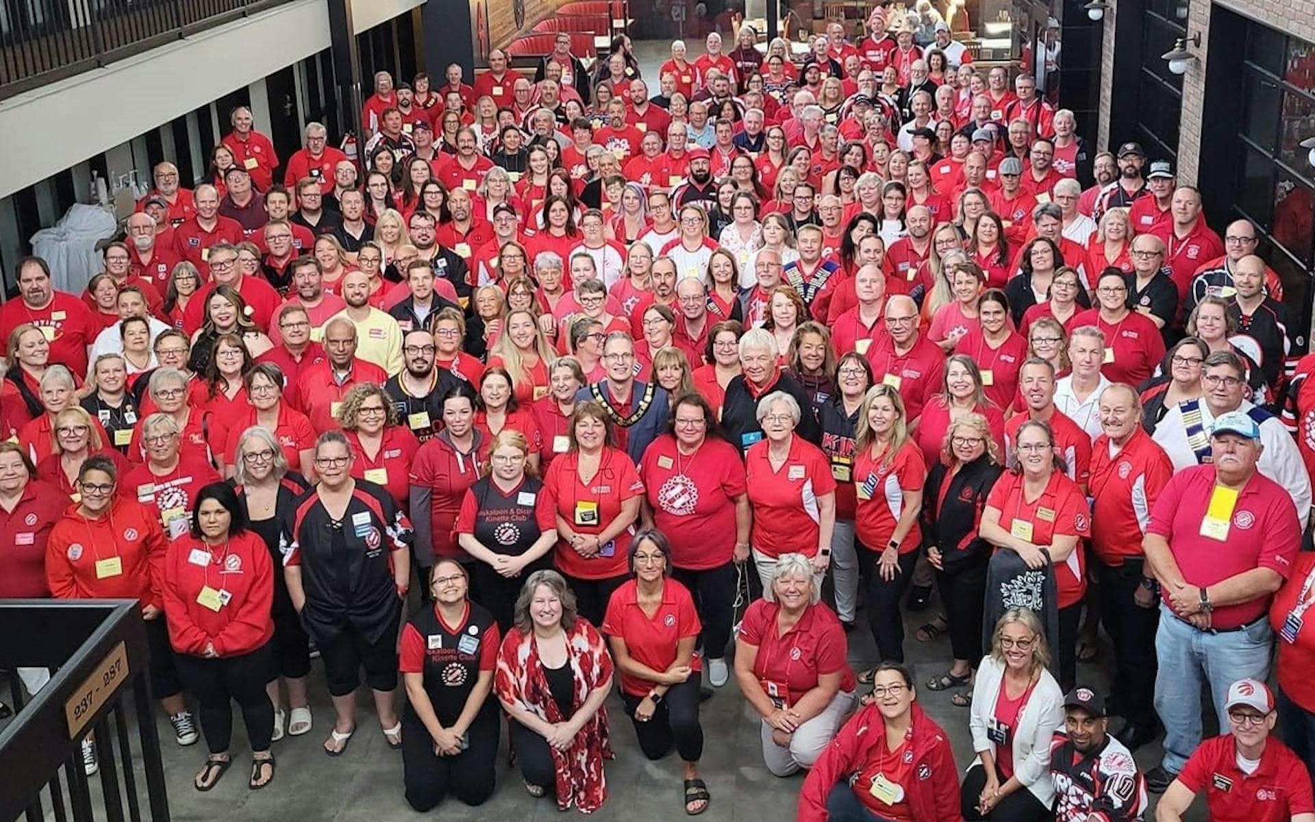 A huge group of Kin Canada volunteers in red shirts pose for an overhead picture