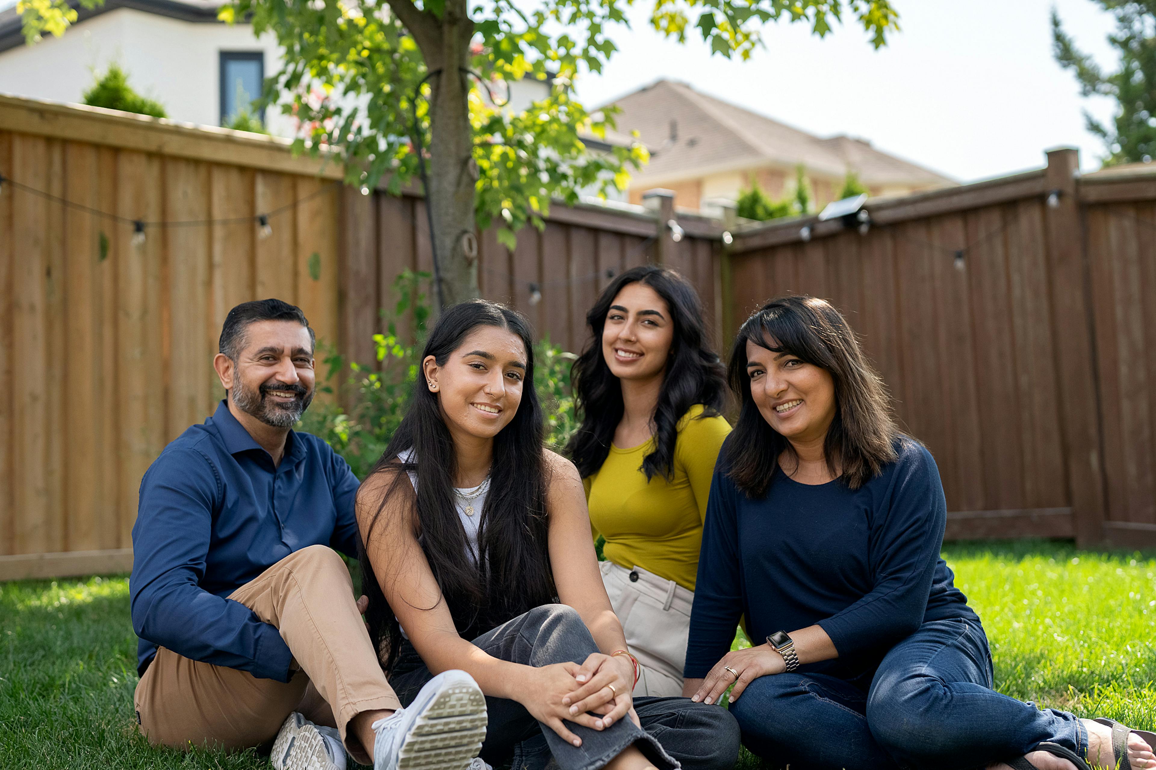 a family of four lounge on a lawn