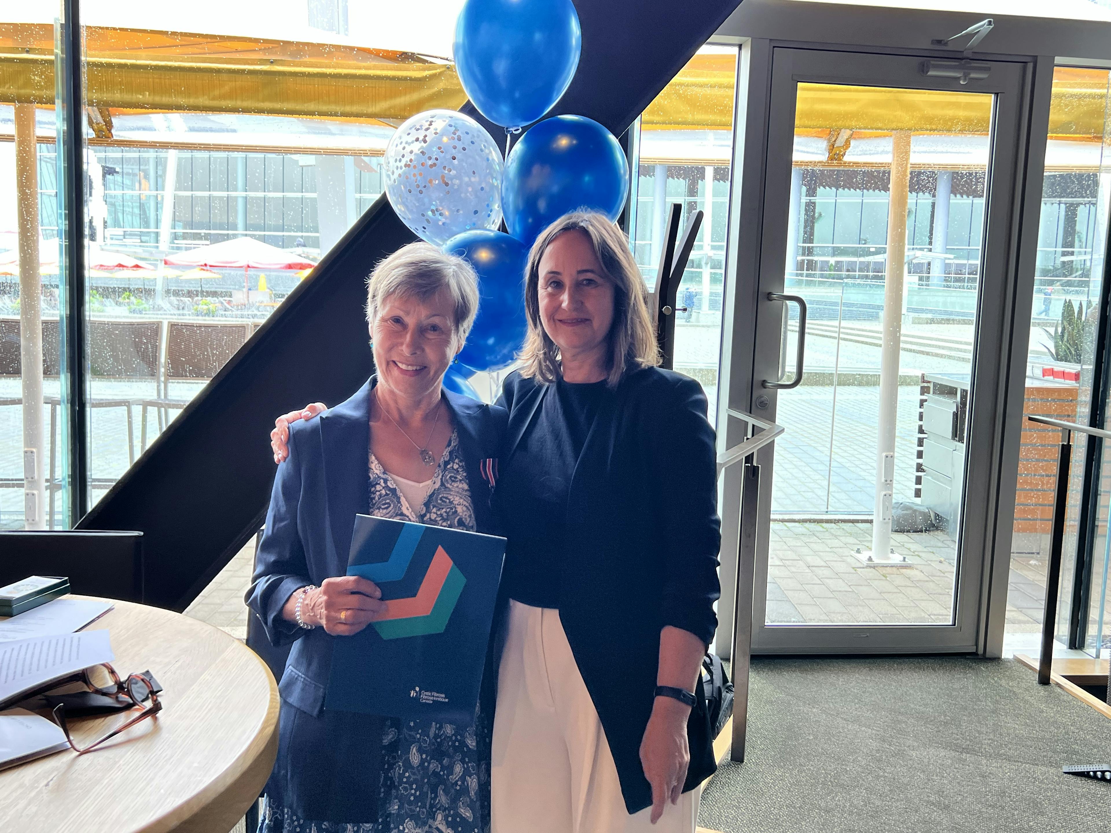 Chris Black stands with Kelly Grover to accept her KCCM