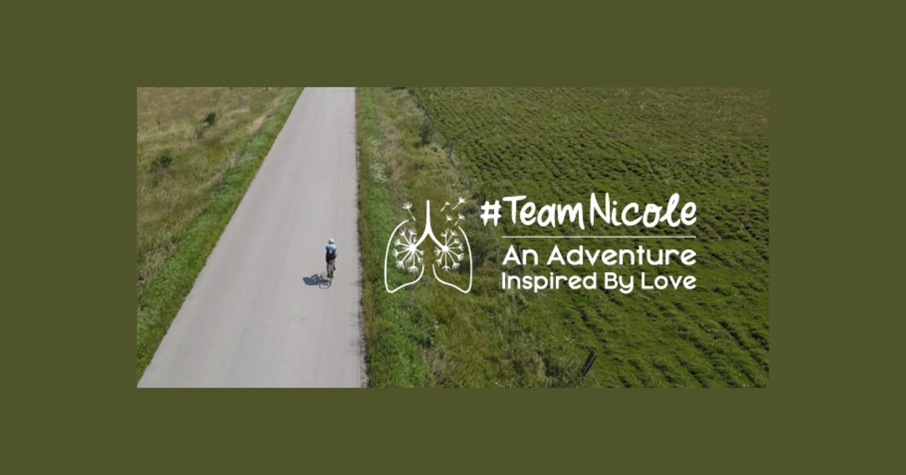 A single cyclist on a vast country road.