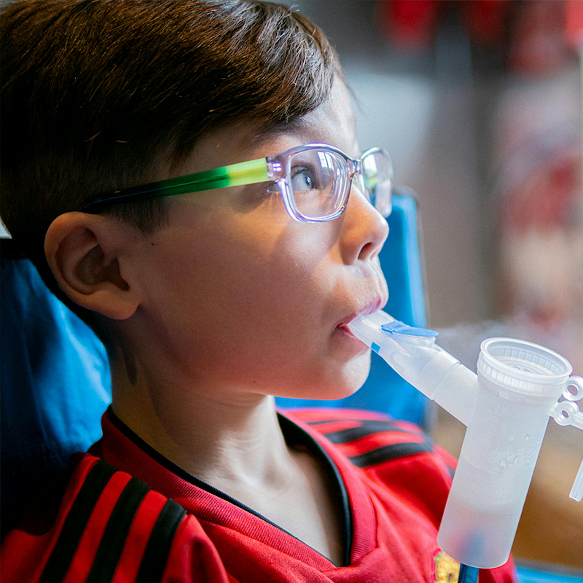 A young boy using a nebulizer for CF treatment.