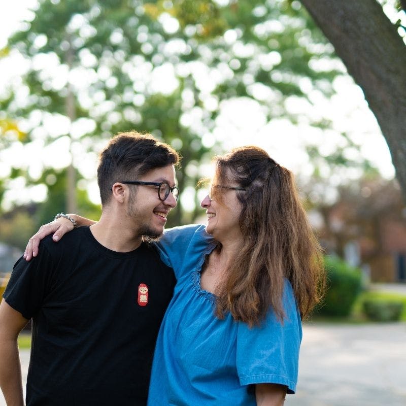 A mother who looks with pride at her adult son who lives with cystic fibrosis