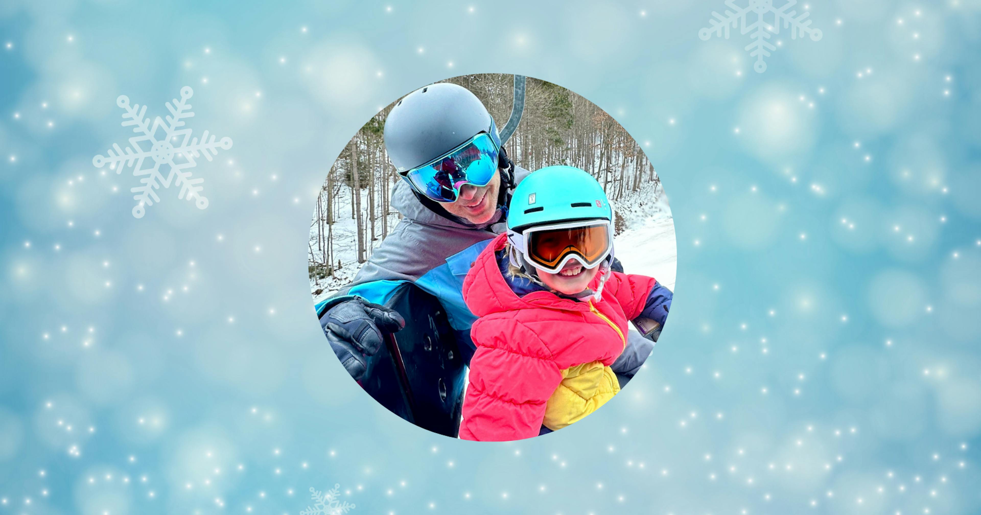 A father and daughter ride the ski lift on a winter day