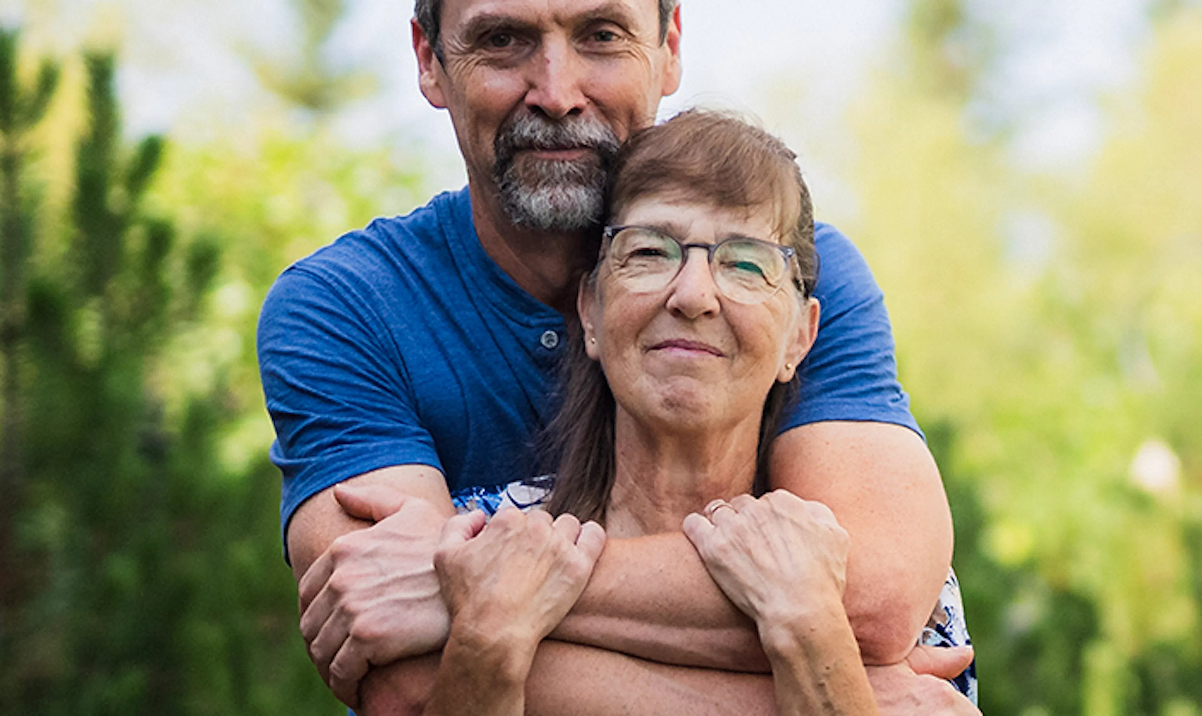 Lorna and her husband embrace outside. 