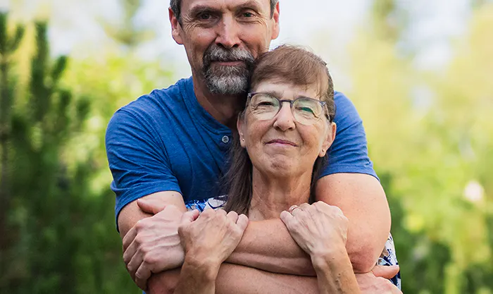 Lorna and her husband embrace outside.