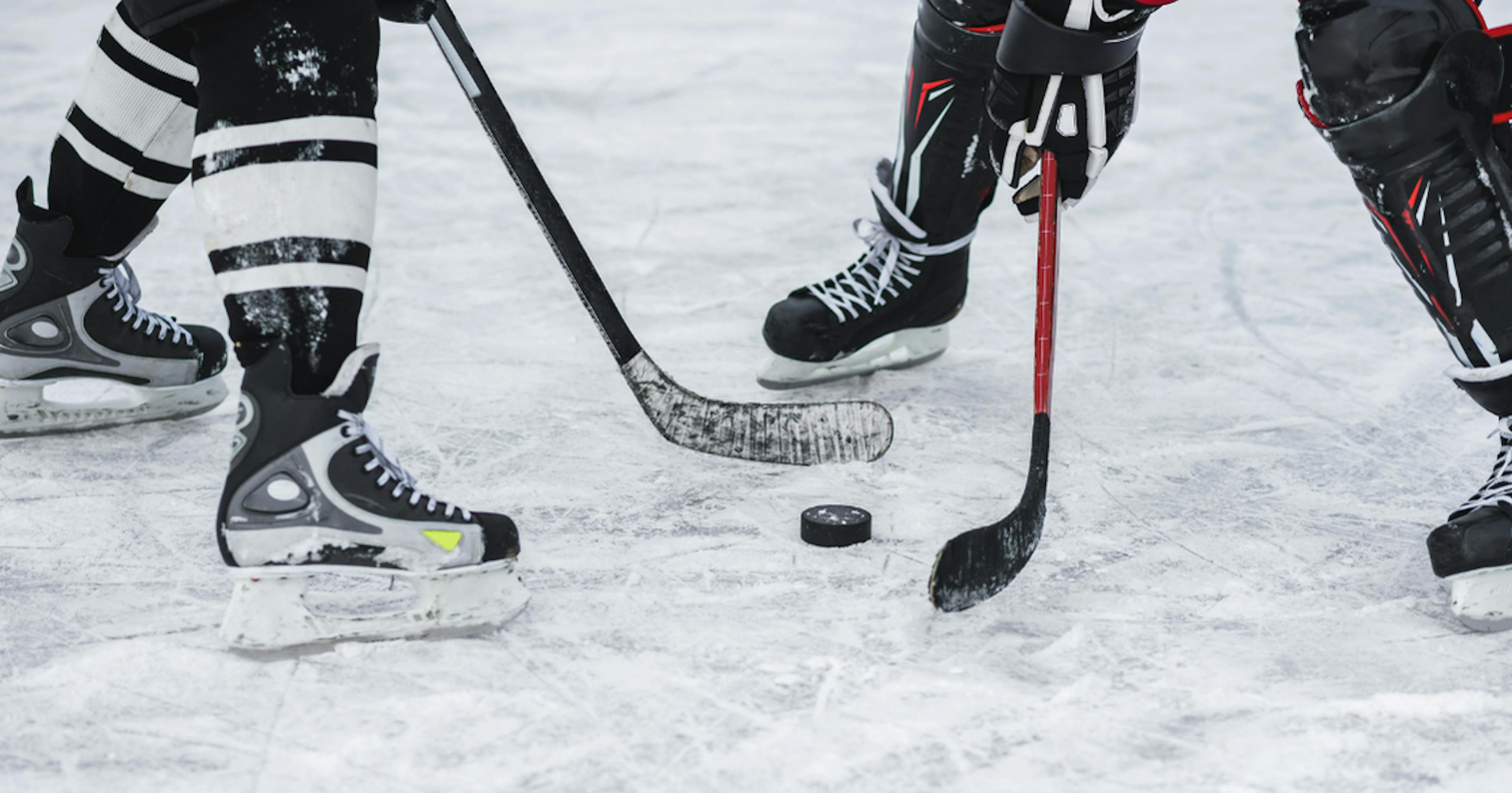 Two hockey players face off on the ice.