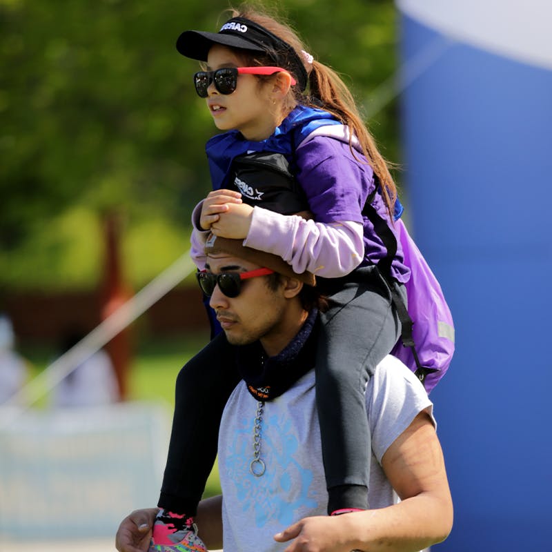 Un jeune père portant sa fille sur ses épaules lors de la Marche FK.