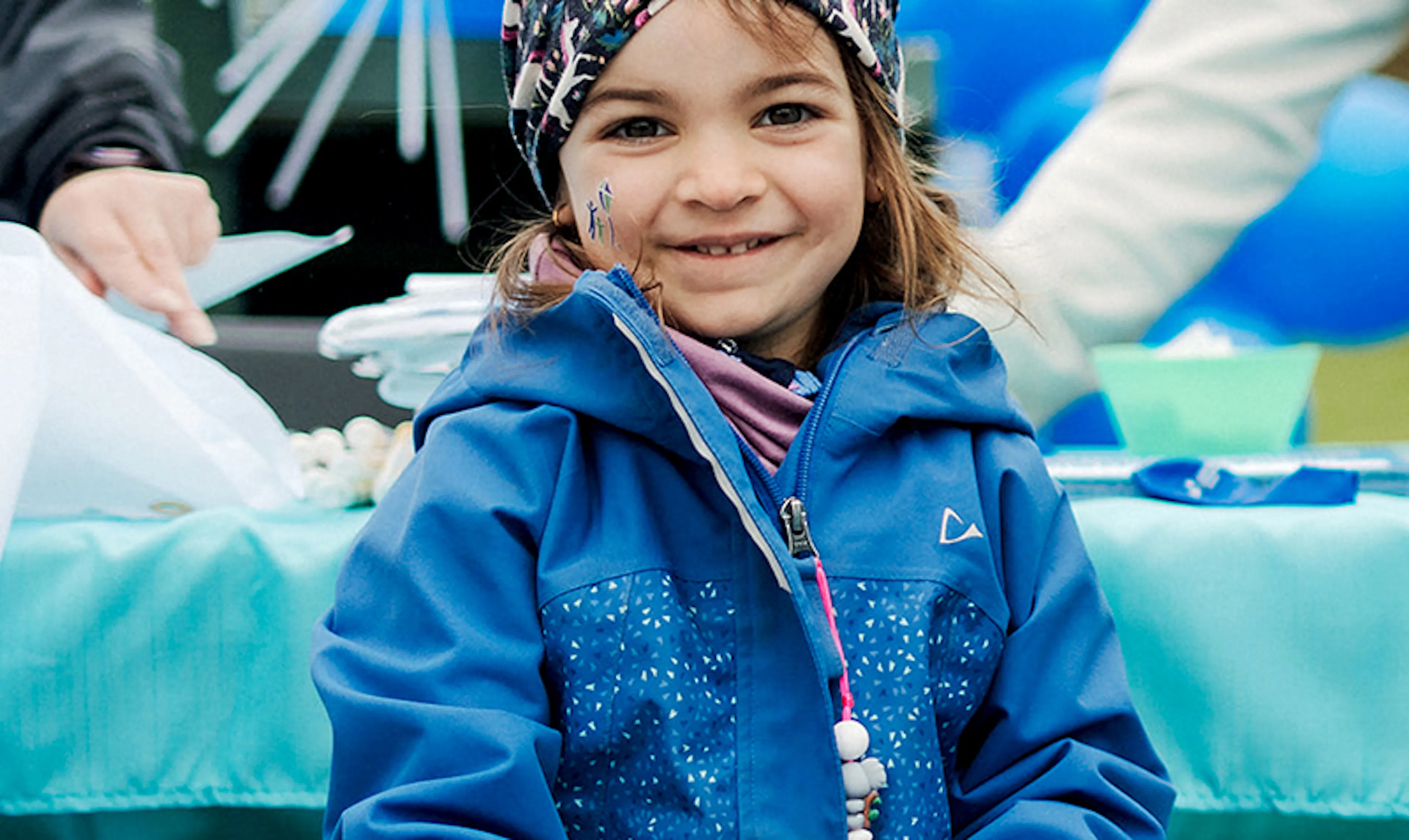 A young walker wearing a bandana and blue rain coat