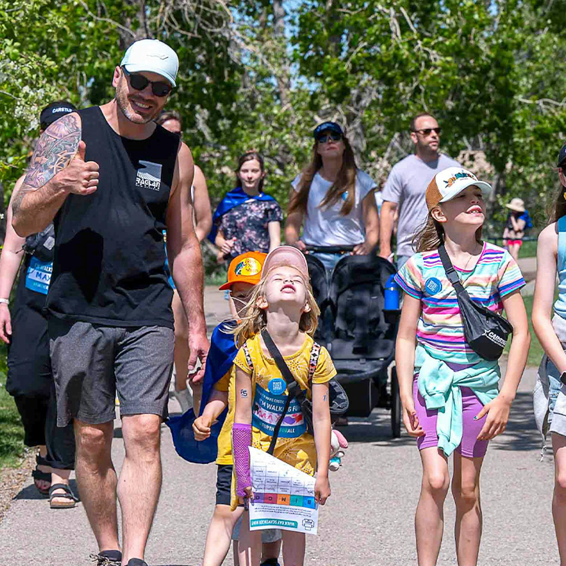 Un père et ses deux jeunes filles portant des vêtements de la Marche FK.