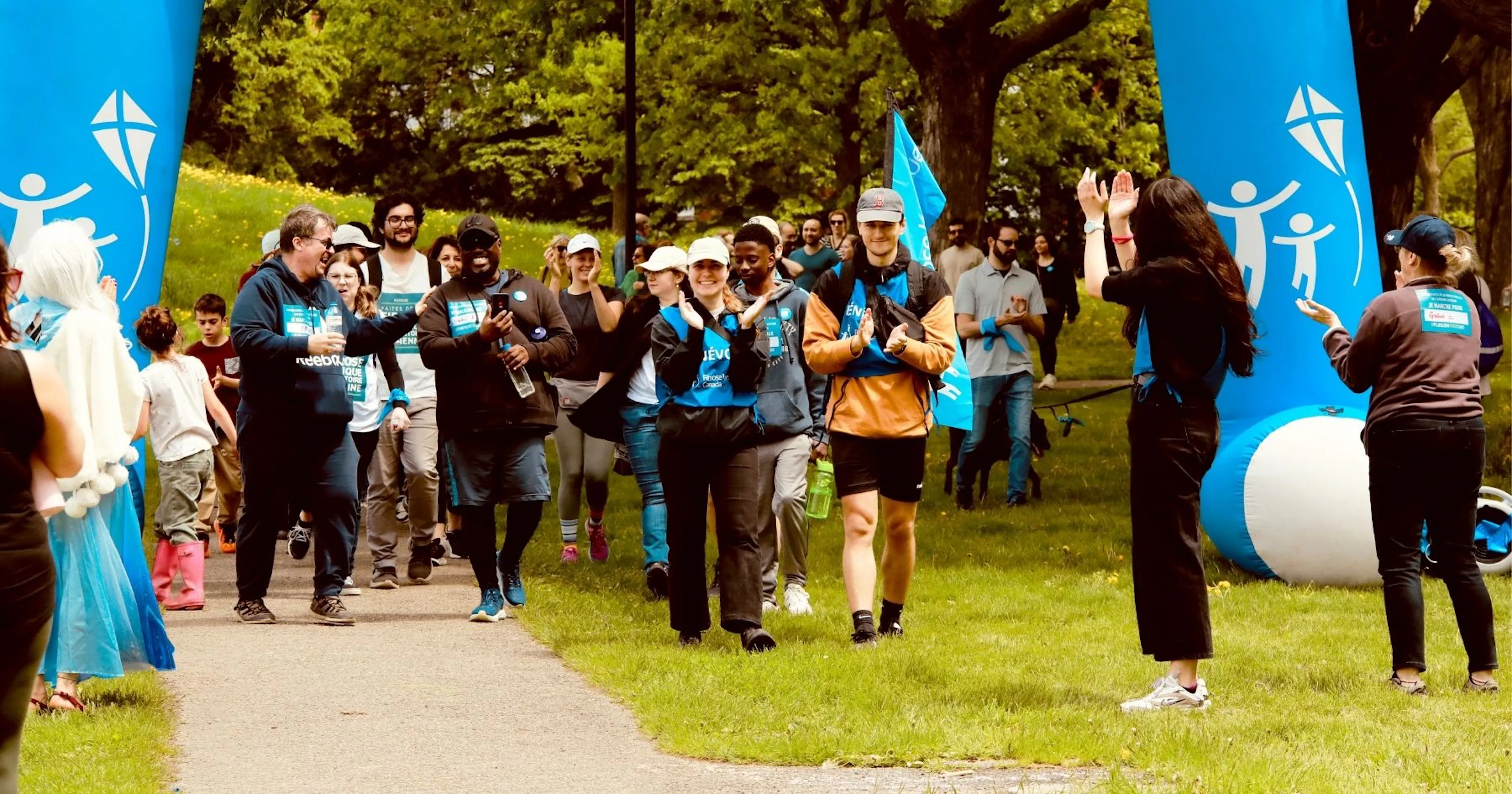 Un grand groupe de marcheurs franchit la ligne d’arrivée.