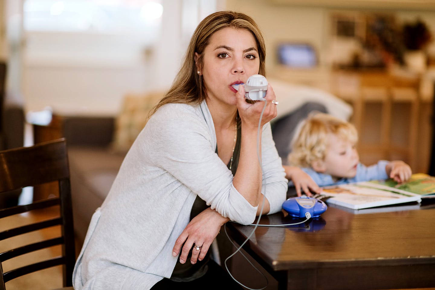 jeune femme utilisant un appareil respiratoire à son domicile