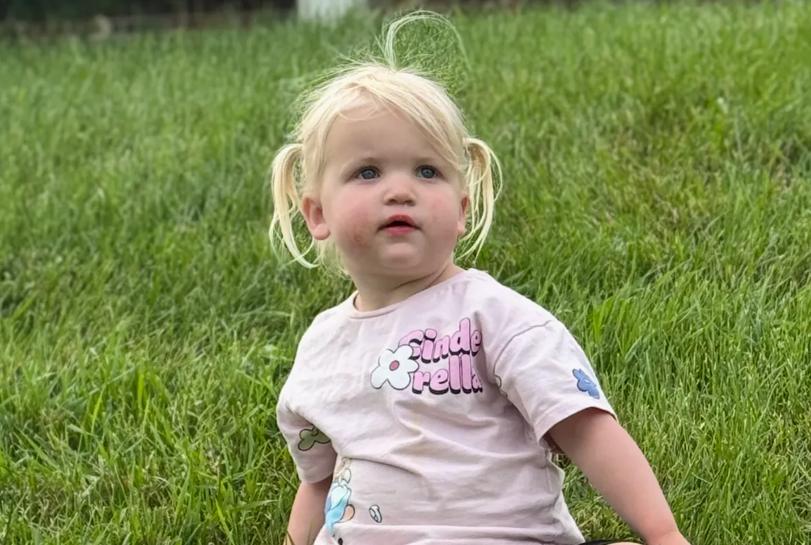 Savannah, 2, sitting in the grass