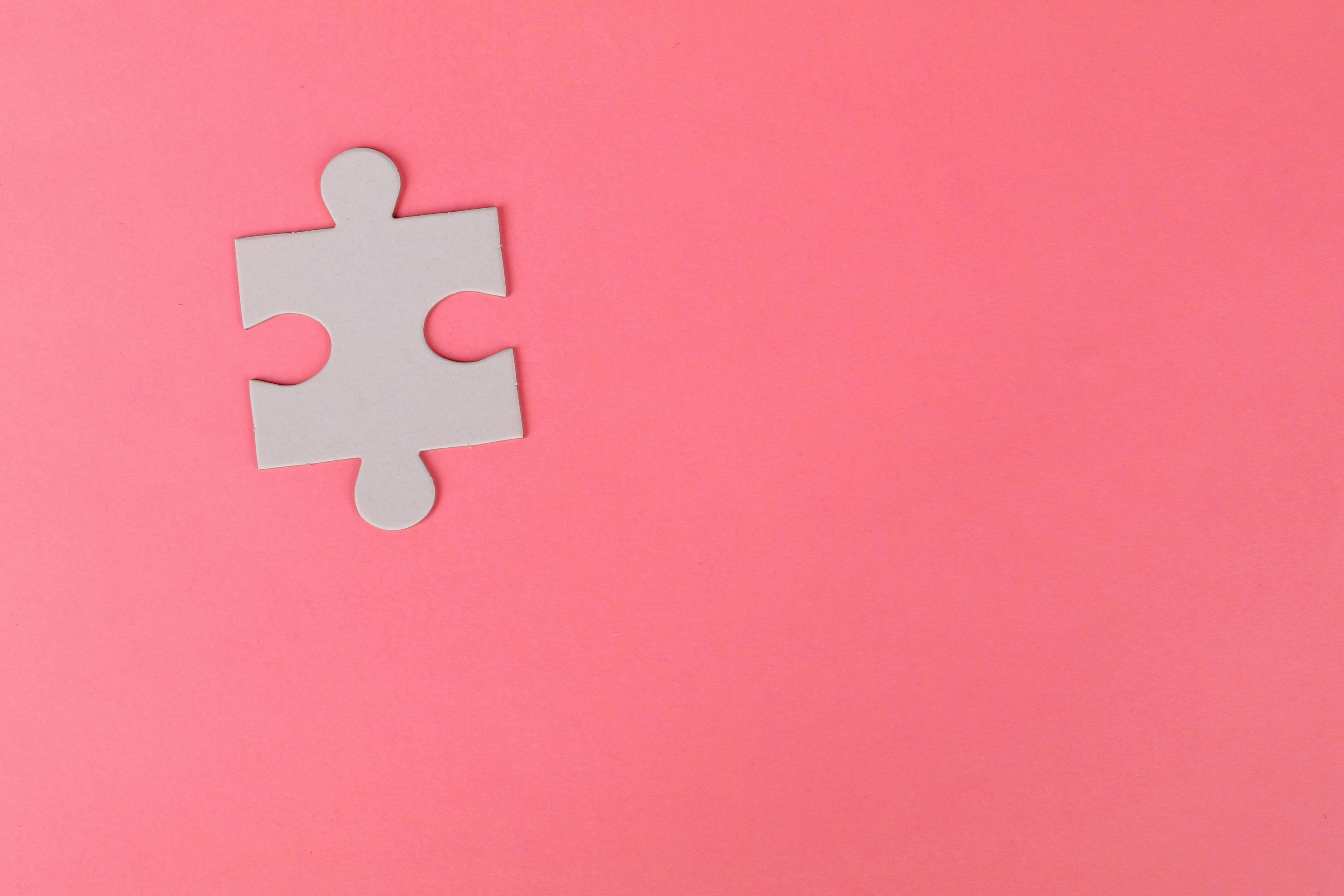 Puzzle piece on pink background