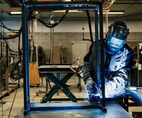Une personne travaillant sur un cadre de meuble dans l'atelier Dacota.