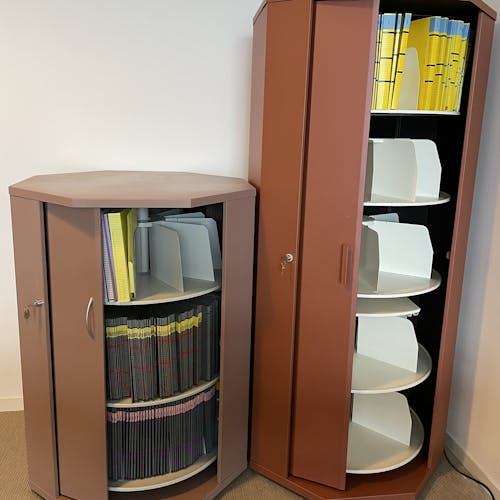 Armoires rotatives octogonales avec deux tailles, une grande et une moyenne ouvertes avec des dossiers à l'intérieur.