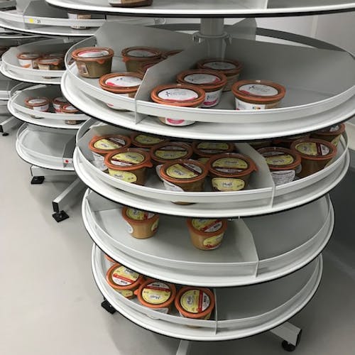 Zoom sur un étage d'une colonne rotative ronde avec des pots de nourritures dessus