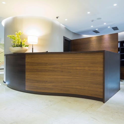 Espace d'accueil pour le public avec un bureau en bois pour la réception