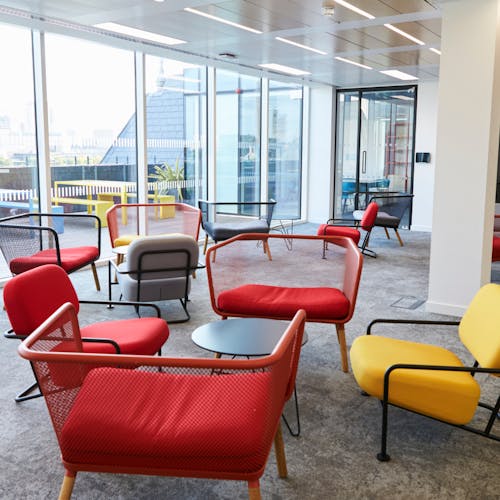 Espace d'accueil pour le public avec des tables basses et des chaises