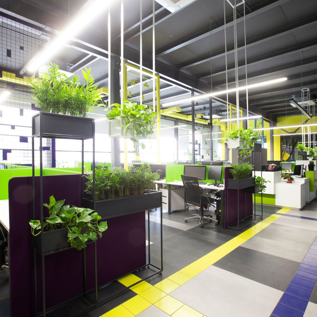 Un espace de travail végétalisé avec des bureaux, des chaises et des plantes