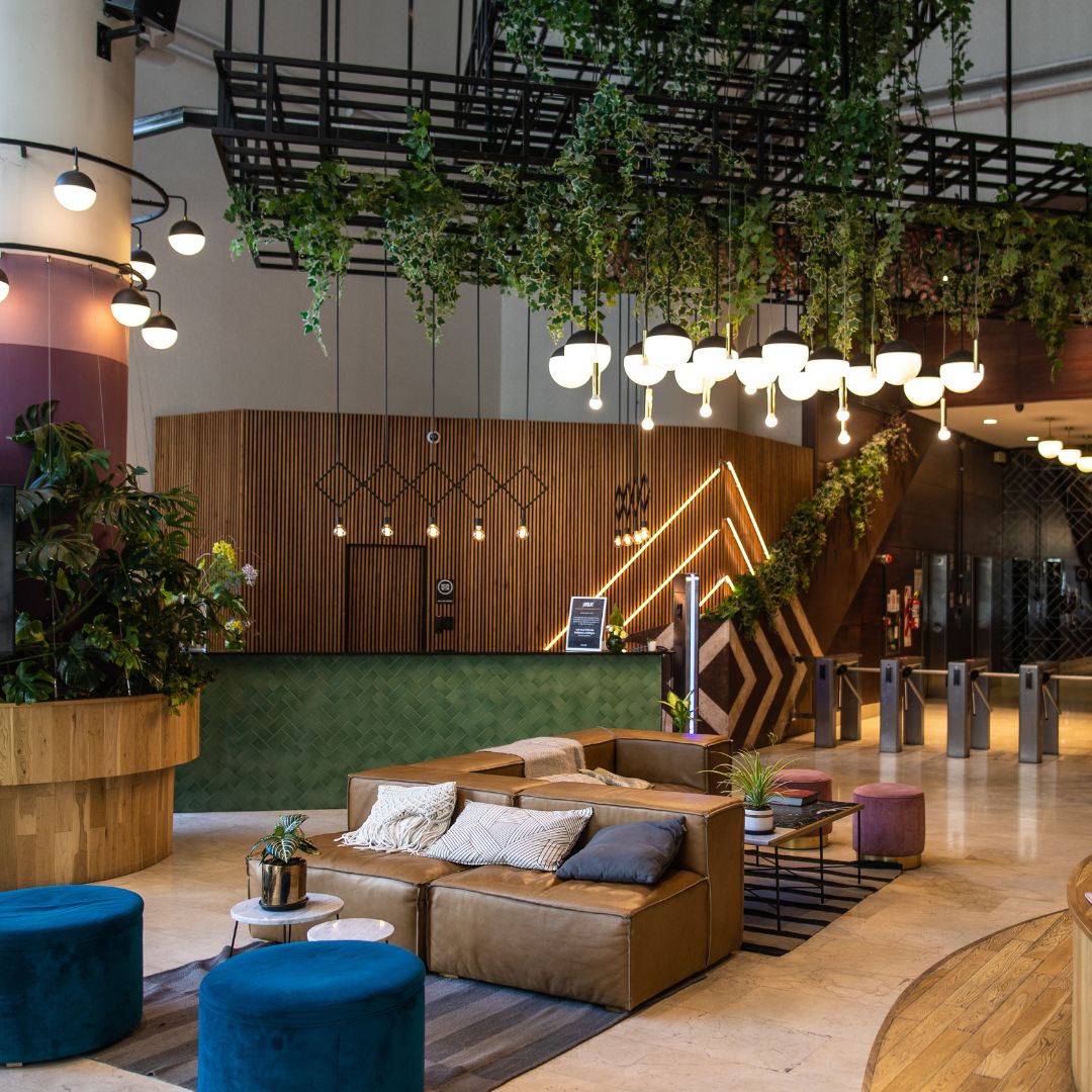 Un espace d'accueil pour le public végétalisé avec canapés et un bureau d'accueil