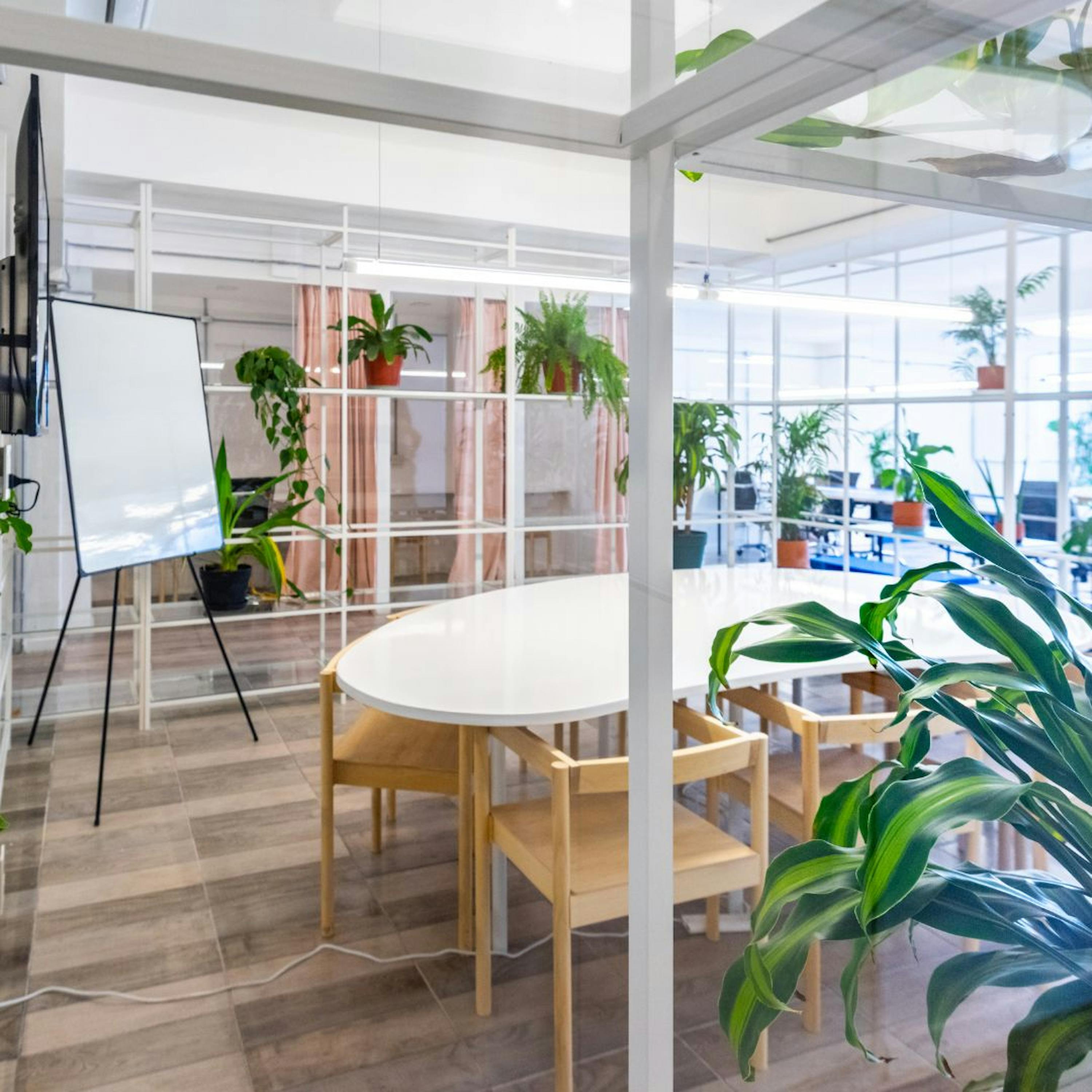 Un espace de travail végétalisé avec des bureaux, des chaises et des plantes