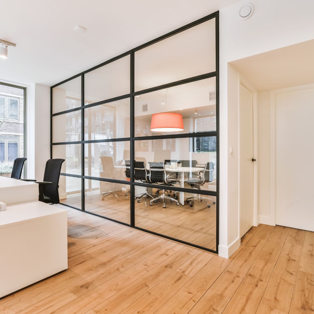 Un espace de travail séparé en deux par une grande verrière