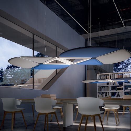 Grand salle avec une bibliothèque, une table et des chaises. Au dessus un système posé par Dacota pour l’acoustique de la pièce