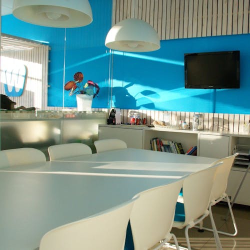 Espace de détente avec un mur bleu, une grande table et des chaises
