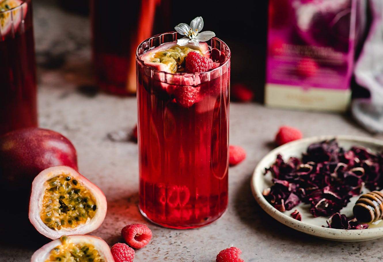 Mocktail rouge au carcadet Passion Framboise dans un verre de thé glacé.