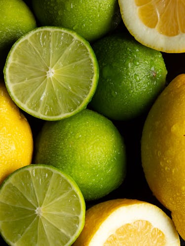 Frutas enteras y frutas cortadas de bergamotas amarillas y bergamotas verdes.